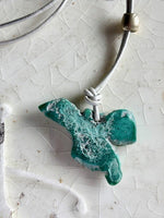 Turquoise angel on white leather